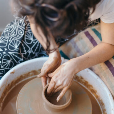 person throwing on the pottery wheel